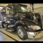 black Peterbilt semi truck cab with shiny exterior in detailing shop